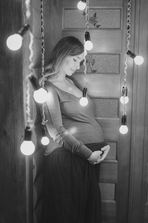 a pregnant woman on a lamps backgroundの写真素材