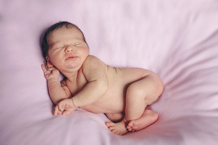Portrait of newborn baby on a pink background.の写真素材