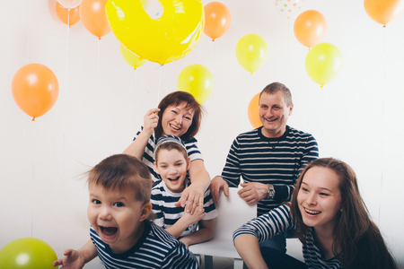 a group of five people on the background of balloons. Family photo at the partyの写真素材