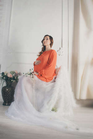 pregnant woman in red and white on a white backgroundの写真素材