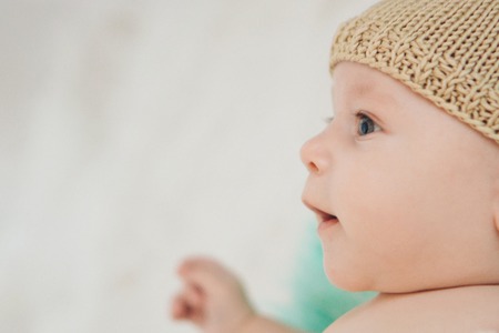 portrait of a child in profile in a knitted hat on a white backgroundの写真素材