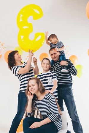 a group of five people on the background of balloons. Family photo at the partyの写真素材