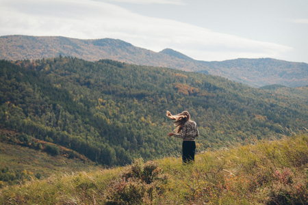 The man on the background of wild nature. Russian mountains, plains, fields. Photo of a woman in full heightの写真素材