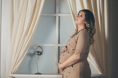 a pregnant woman holding hands on bellyの写真素材