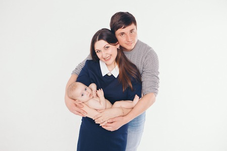 Baby on the hands of parents on a white background.の写真素材
