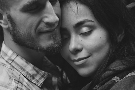 portrait in black and white: a man and a woman hugging. Guy and girl face to faceの写真素材