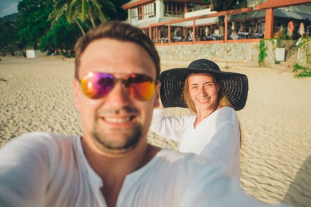 Portrait of a man and a woman: a couple takes a selfie on the beach. Husband and wife on vacationの写真素材