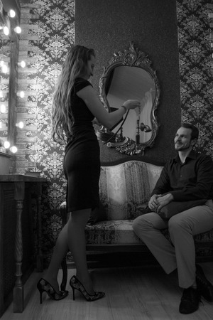 Black and white photo: a woman gives a man a phone. Business or romantic relationshipの写真素材