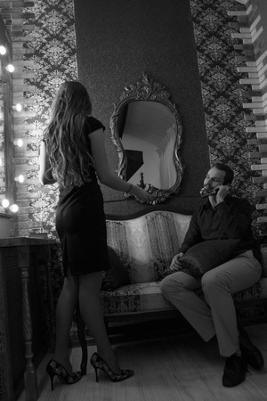 Black and white photo: a woman gives a man a phone. Business or romantic relationshipの写真素材