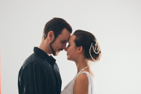 portrait: man and woman kissing on white background. The bride and groom in an isolated photo. Husband and wife face to faceの写真素材