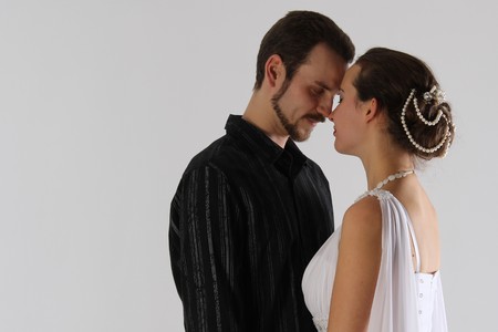 portrait: man and woman kissing on white background. The bride and groom in an isolated photo. Husband and wife face to faceの写真素材