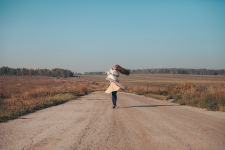 A woman with a child in his arms on the road in the middle of a wastelandの写真素材