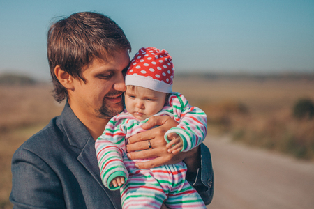 A man with a child in his arms on the road in the middle of a wastelandの写真素材