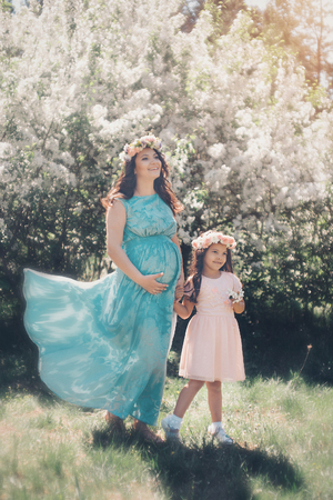 pregnant woman and little girl: family photo outdoors. fashion for the whole familyの写真素材