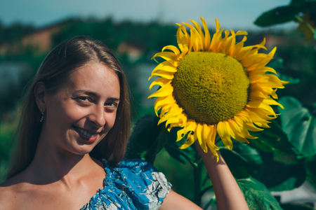 Portrait of a girl with flower on a background of green foliageの写真素材