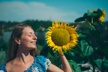 Portrait of a girl with flower on a background of green foliageの写真素材