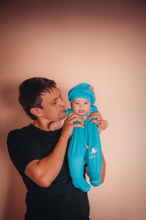 baby on the hands of father. man and child in a black and blueの写真素材