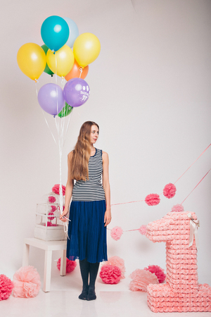 Blonde with coloured balloons on white background.の写真素材