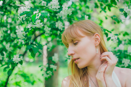 Portrait of a girl on a background of green foliageの写真素材