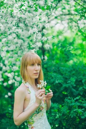 Portrait of a girl on a background of green foliageの写真素材