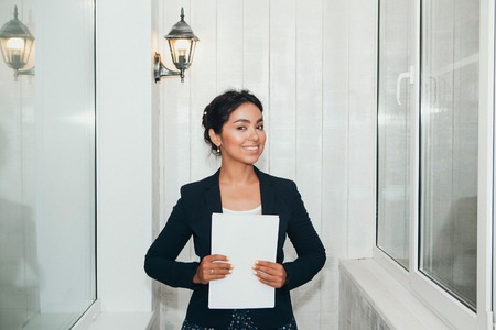 girl in a business suit Asian appearance on a white background in the office working with documentsの写真素材
