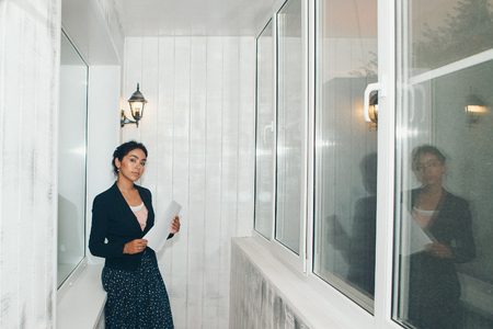 girl in a business suit Asian appearance on a white background in the office working with documentsの写真素材