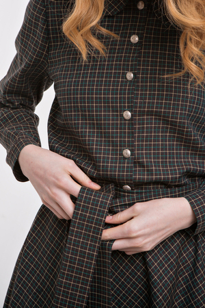 girl ties a belt on a dress. Hands on fabric background close-up. Element of clothesの写真素材