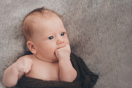 Portrait of newborn baby on a beige background.の写真素材