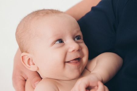 baby on the hands of parents on a white background. a child smiledの写真素材