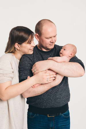 newborn baby lying on the hands of parentsの写真素材