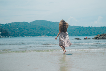 handsome girl on the beach background. Portrait of a woman in white clothes on the seaの写真素材