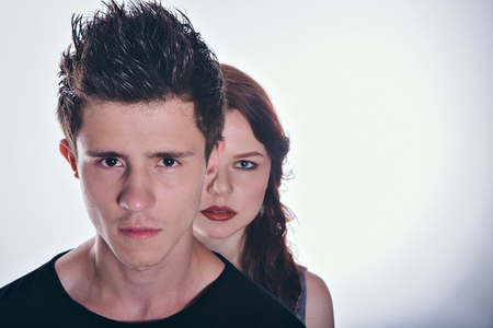 Cropped image of beautiful couple looking at the camera standing straight on white backgroundの写真素材