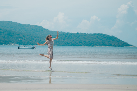 beautiful girl dancing on the beach. Portrait of a woman in white clothes on the sea. Dancer on the sandの写真素材