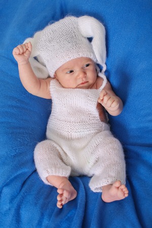 portrait of newborn baby in a hat with ears on a blue background. Newborn fashionの写真素材