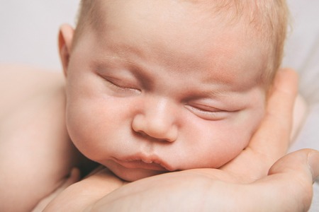 portrait of newborn baby lying on the hands of parentsの写真素材