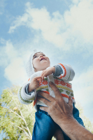 Dad raised his daughter in his arms. Girl in fly