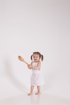 little girl with a ladle in her hand, isolated photo on white backgroundの写真素材