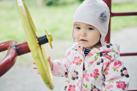 a ittle girl playing in the Playground. children's hand holding the steering wheelの写真素材