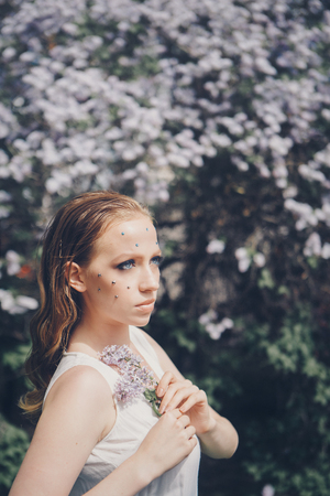 beautiful girl model with bright makeup among pink flowers. Portrait of a woman with rhinestones on her face close-upの写真素材