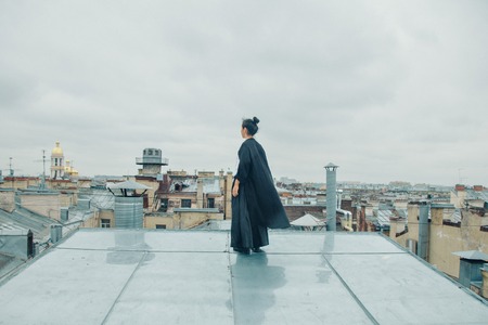 girl in black clothes standing on the edge of the roofの写真素材