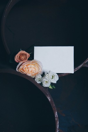 white sheet of paper and flowers on a large iron pipeの写真素材