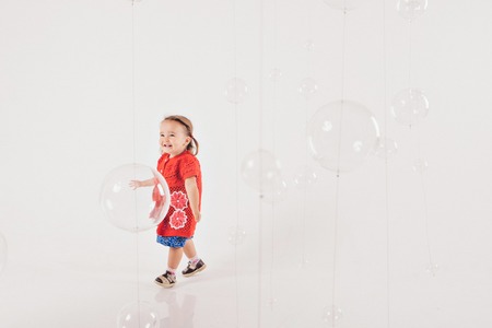portarit of little girl in red and blue clothes on a white background. fashion for babyの写真素材
