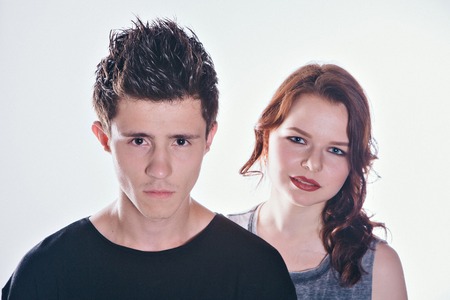 Cropped image of beautiful couple looking at the camera standing straight on white backgroundの写真素材