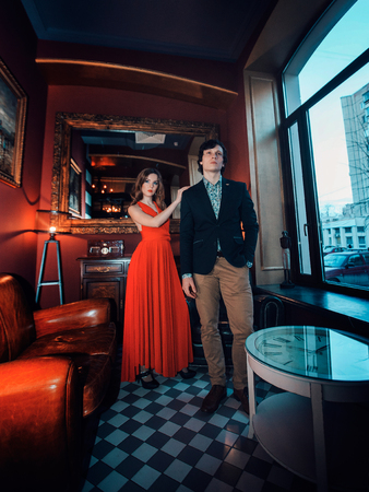 beautiful girl in dress posing next to businessmanの写真素材