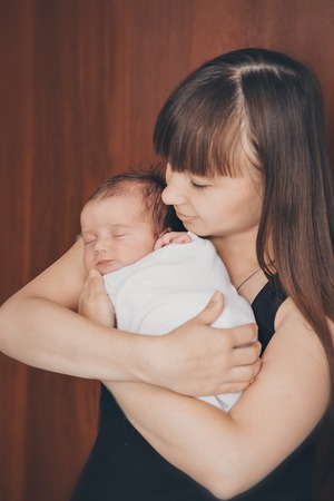 newborn baby in the arms of the mother. Woman holding a childの写真素材