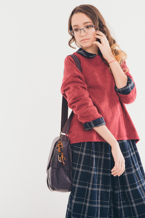 beautiful young girl with glasses and bag posing on white backgroundの写真素材