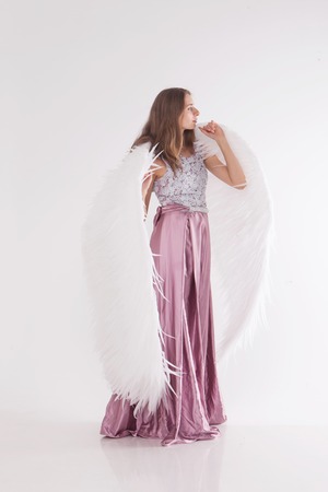 Girl in pink dress with angel wings on white background. Angel-womanの写真素材