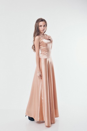 beautiful long-haired girl in long dress dancing on white backgroundの写真素材