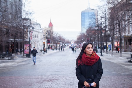 portrait of a beautiful brunette Asian girl appearance in a red scarf on the streetの写真素材