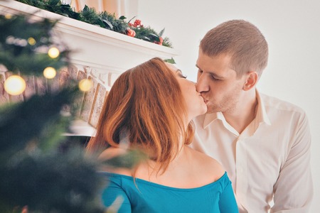 photo of a man and woman through the branches of a Christmas treeの写真素材